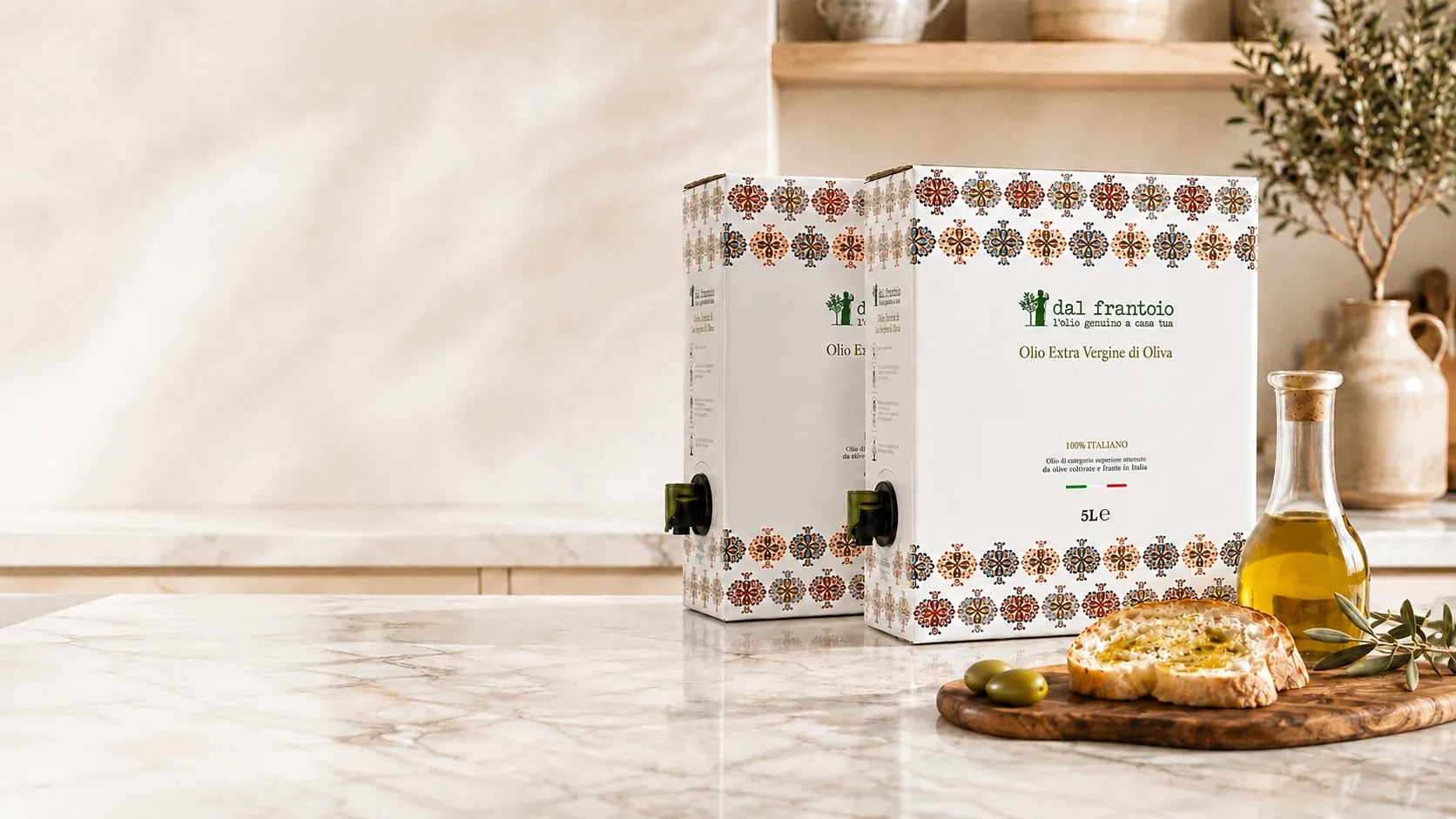 2 Bag-in-Box Dal Frantoio da 5 L su un piano di marmo, con la caraffa dell’olio e il pane